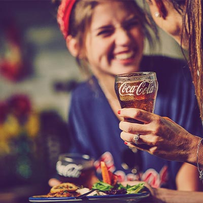 Two Women Drinking Coca-Cola with a meal