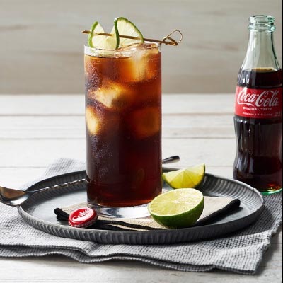 coke glass on tray with coke bottle next to it